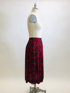 Feminine vintage red pleated skirt with a blue and purple paisley design. Midi length with side zipper closure. Beautiful vintage ribbon on inside hem finishing. A lovely piece for in-between seasons.