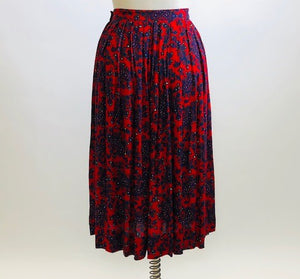 Feminine vintage red pleated skirt with a blue and purple paisley design. Midi length with side zipper closure. Beautiful vintage ribbon on inside hem finishing. A lovely piece for in-between seasons.