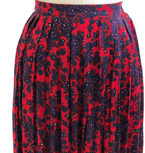 Feminine vintage red pleated skirt with a blue and purple paisley design. Midi length with side zipper closure. Beautiful vintage ribbon on inside hem finishing. A lovely piece for in-between seasons.