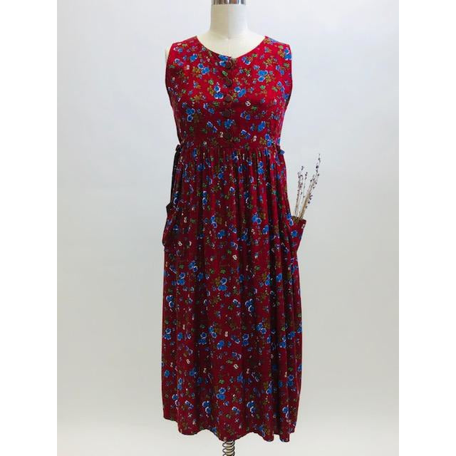 Burgundy sleeveless prairie dress with little blue and white flowers, gathered high doll waist and patch pockets to hold your freshly-picked flowers. Loose fit with double ties at waist to adjust for contouring. Midi length. This adorable dress looks homemade. 