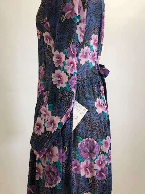 Gorgeous, airy long sleeve dress in purple and blue florals. This is made of a lightweight, sheer fabric so you will want to wear a light slip underneath. It features a v-shaped waistline with gathered skirt, and side seam pockets. The waist can be adjusted with waist ties at back. Button opening at back of bodice with a slight boat neck style. 