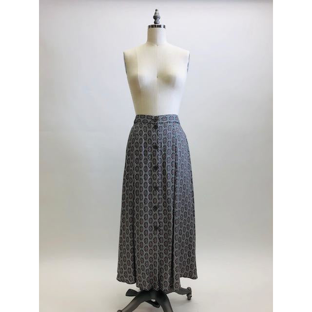 Vintage A-line maxi skirt with buttons down center front and elasticated back waistband in a soft viscose fabric in a white, black and gray regal-style print. Beautifully lightweight for in-between seasons and pairs nicely with t-shirts, sweaters and cardigans. Vintage Timothy Eaton Co. Ltd. label. 