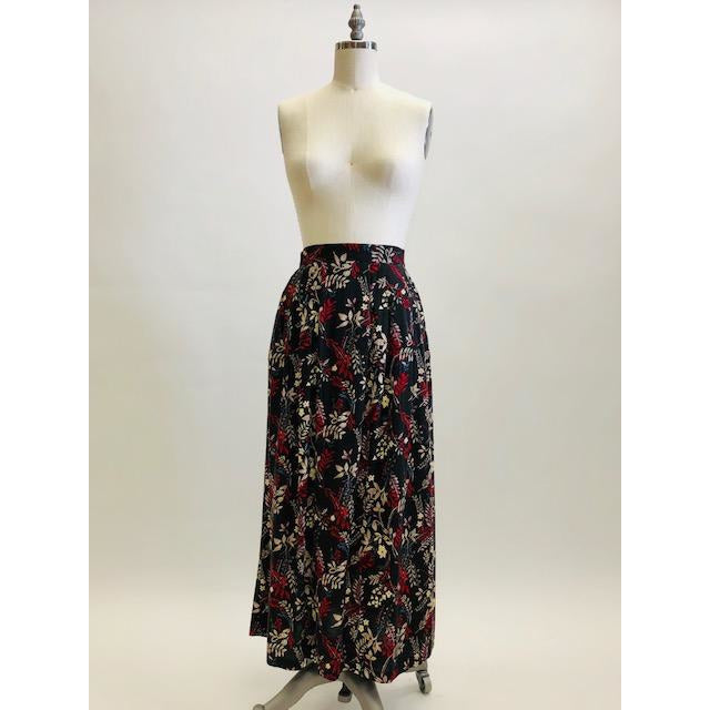 Vintage rayon maxi skirt with pleats at waistband featuring red, taupe and beige foliage and floral print against black background. Side seam pockets, and elasticated waistband in the back. Beautiful as an in-between seasons skirt and for a fall walk with tights and little boots.