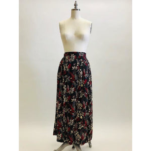 Vintage rayon maxi skirt with pleats at waistband featuring red, taupe and beige foliage and floral print against black background. Side seam pockets, and elasticated waistband in the back. Beautiful as an in-between seasons skirt and for a fall walk with tights and little boots.