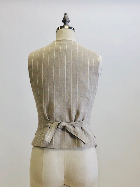 Oatmeal and white pinstripe lined vest with front flap pockets. Back waist ties for a fitted waist look. 