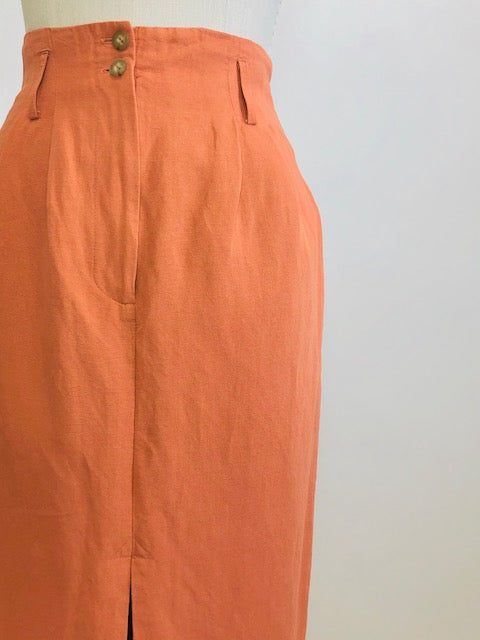 Bright terracotta midi skirt with feminine front slit and front zipper closer. Belt loops and cute back pocket with a nice casual linen/rayon texture. Super cute when worn with flat sandals. 