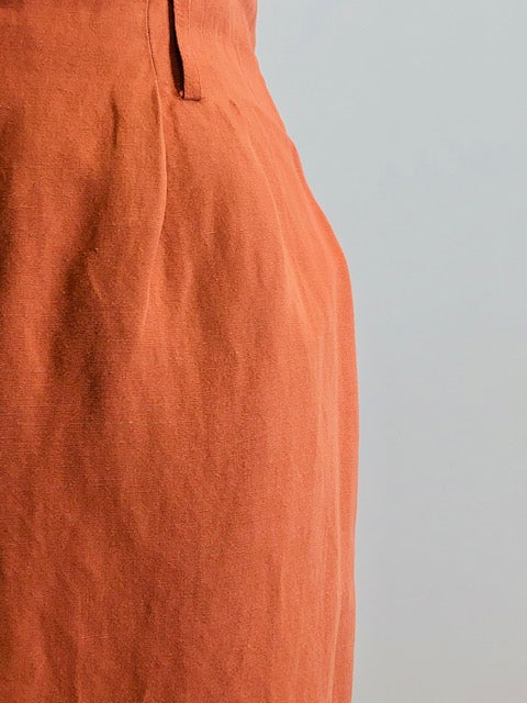 Bright terracotta midi skirt with feminine front slit and front zipper closer. Belt loops and cute back pocket with a nice casual linen/rayon texture. Super cute when worn with flat sandals. 