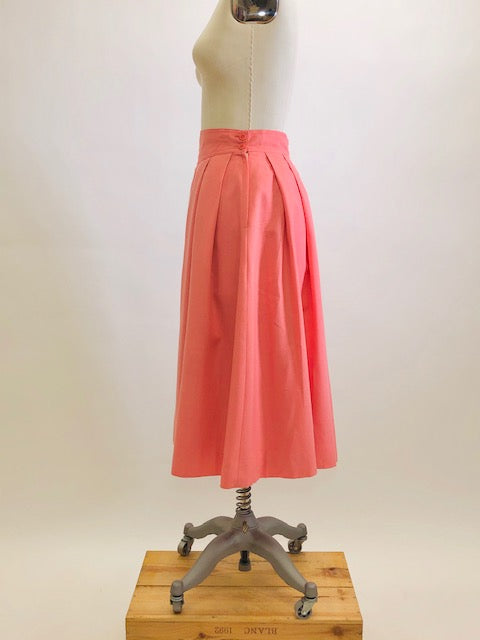 Vintage coral pink lined circle skirt with pleats at waist, yoke waistband, side seam lap zipper.  Sweet vintage skirt with ribbon hem finishing - perfect for twirling. 