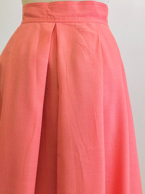 Vintage coral pink lined circle skirt with pleats at waist, yoke waistband, side seam lap zipper.  Sweet vintage skirt with ribbon hem finishing - perfect for twirling. 