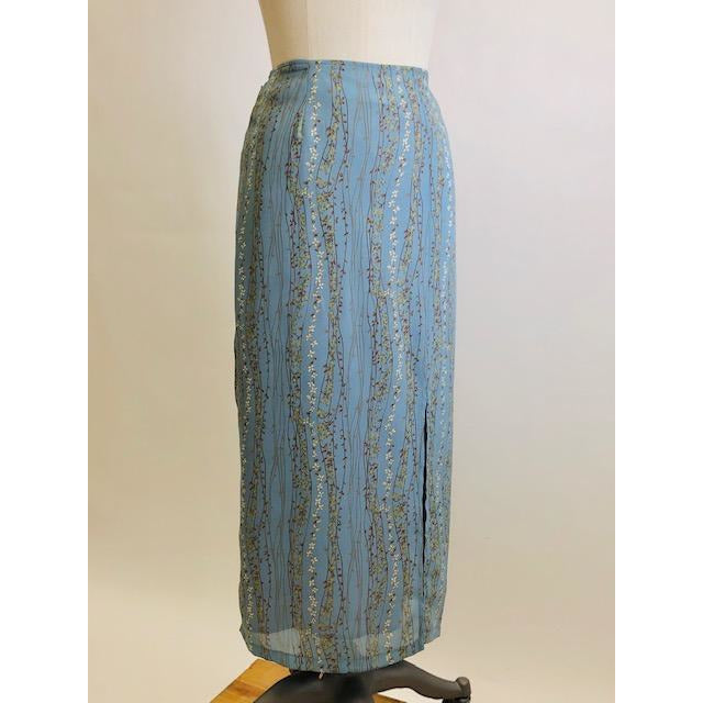 Romantic powder blue maxi skirt with delicate field vines. Lined skirt with front slit, side waist ties and back zipper closure.  