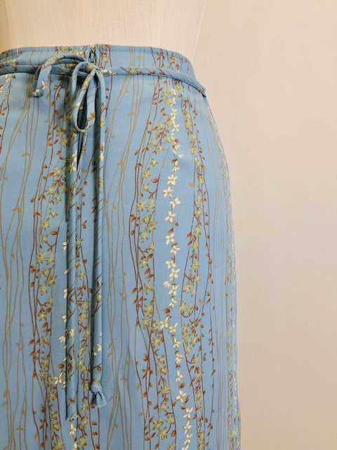 Romantic powder blue maxi skirt with delicate field vines. Lined skirt with front slit, side waist ties and back zipper closure.  