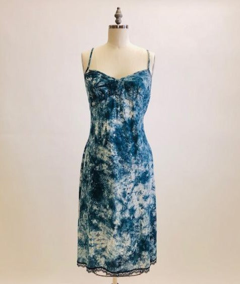 Holt Renfrew Studio cotton slip midi dress in tie-dye indigo print with spaghetti straps, feminine lace hem trim, empire bust style, and center back zipper closure. 