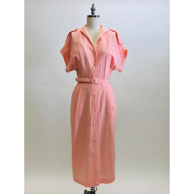 Vintage pink button down long dress with kimono sleeves with an 80s style loose fit on top and side seam pockets. Interesting asymmetrical design-shaped bust pockets. Comes with matching belt. Fabric is unknown, has a textured feel, could be a viscose/cotton blend. 