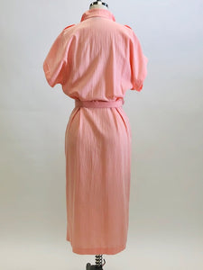 Vintage pink button down long dress with kimono sleeves with an 80s style loose fit on top and side seam pockets. Interesting asymmetrical design-shaped bust pockets. Comes with matching belt. Fabric is unknown, has a textured feel, could be a viscose/cotton blend. 