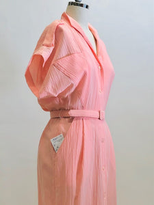 Vintage pink button down long dress with kimono sleeves with an 80s style loose fit on top and side seam pockets. Interesting asymmetrical design-shaped bust pockets. Comes with matching belt. Fabric is unknown, has a textured feel, could be a viscose/cotton blend. 