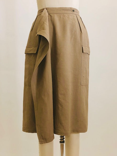 Knee length linen/viscose skirt in a dark khaki and olive tone with interesting snap front wrap overlap at waist, pin tucks at waistband and cargo pockets. Uniquely designed skirt. 