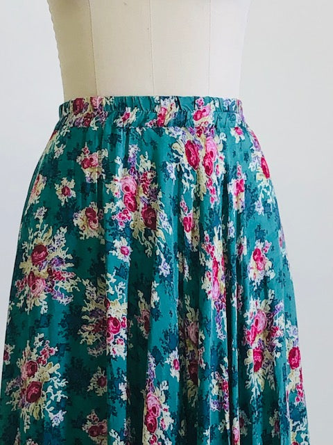 Gorgeous green-tale midi length skirt with feminine roses and elasticated waist. The label states cotton, but it's very drapey, and almost reminds me of a soft lightweight rayon in touch and drape. Has a very light lining. Perfect for twirling. 