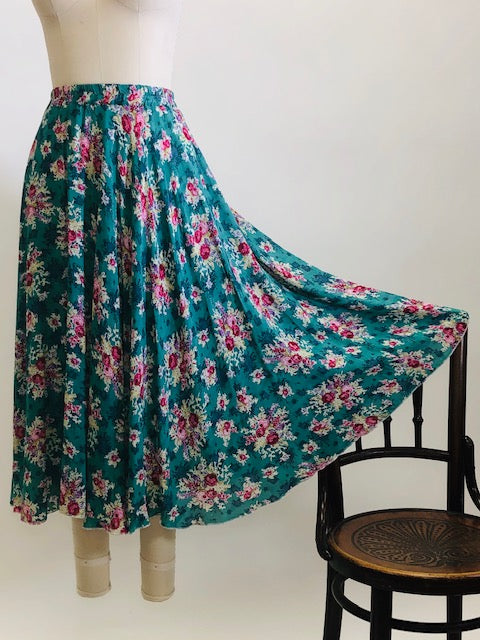 Gorgeous green-tale midi length skirt with feminine roses and elasticated waist. The label states cotton, but it's very drapey, and almost reminds me of a soft lightweight rayon in touch and drape. Has a very light lining. Perfect for twirling. 