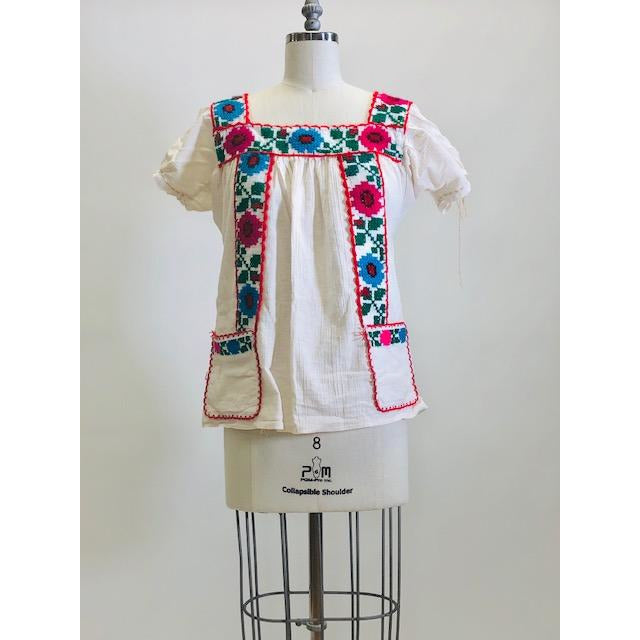 Blousy top with embroidered flower details, and front patch pockets in off-white cotton gauze fabric. Looks like a special handmade piece.