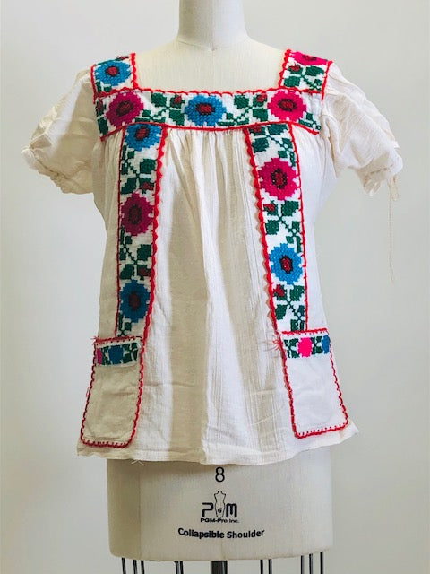 Blousy top with embroidered flower details, and front patch pockets in off-white cotton gauze fabric. Looks like a special handmade piece.