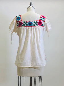 Blousy top with embroidered flower details, and front patch pockets in off-white cotton gauze fabric. Looks like a special handmade piece.