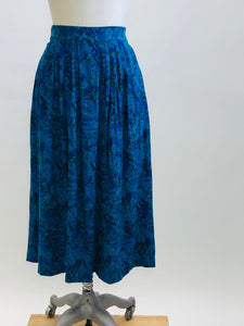 Lovely vintage 80s rayon midi pleated skirt with swirls of turquoise, green, blue and pink accents. This skirt features elasticated back waistband, and inseam side pockets. Made in Canada. 