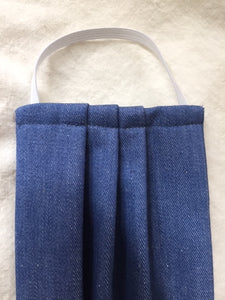 This is a double-layer face mask made of unused deadstock / remnant fabric in a vintage denim. A pleated style that is washable and reusable. Denim cotton-blend. Made in Canada.