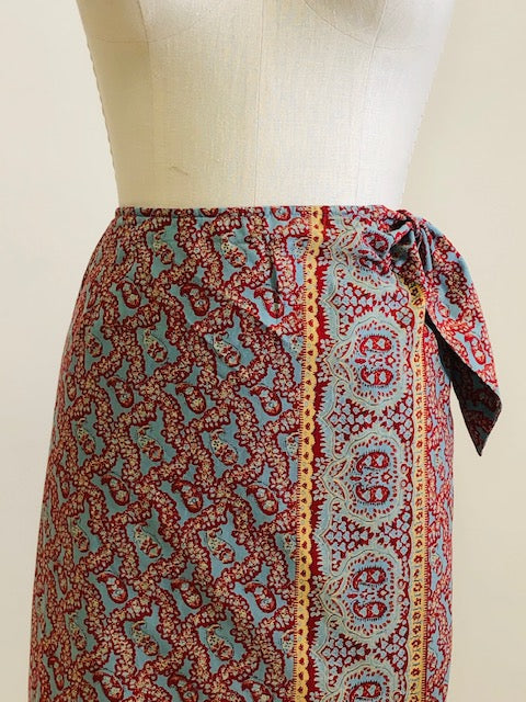 Vintage Ralph Lauren wrap midi cotton skirt with side waist tie in a vibrant paisley print of blues, reds and light orange, accented by a striking border. 