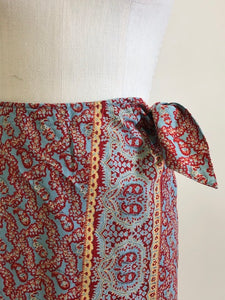 Vintage Ralph Lauren wrap midi cotton skirt with side waist tie in a vibrant paisley print of blues, reds and light orange, accented by a striking border. 